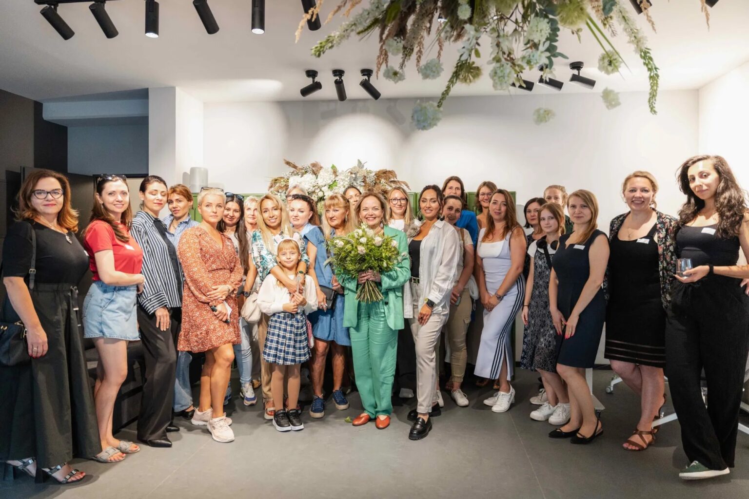 Olga Müller mit Blumenstrauß und Gäste bei der Eröffnung des Womenmatic Space in Leipzig