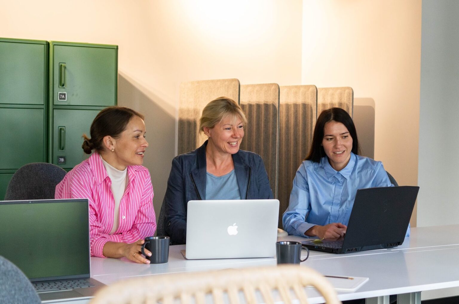 Drei Frauen arbeiten gemeinsam an Laptops im Womenmatic Space